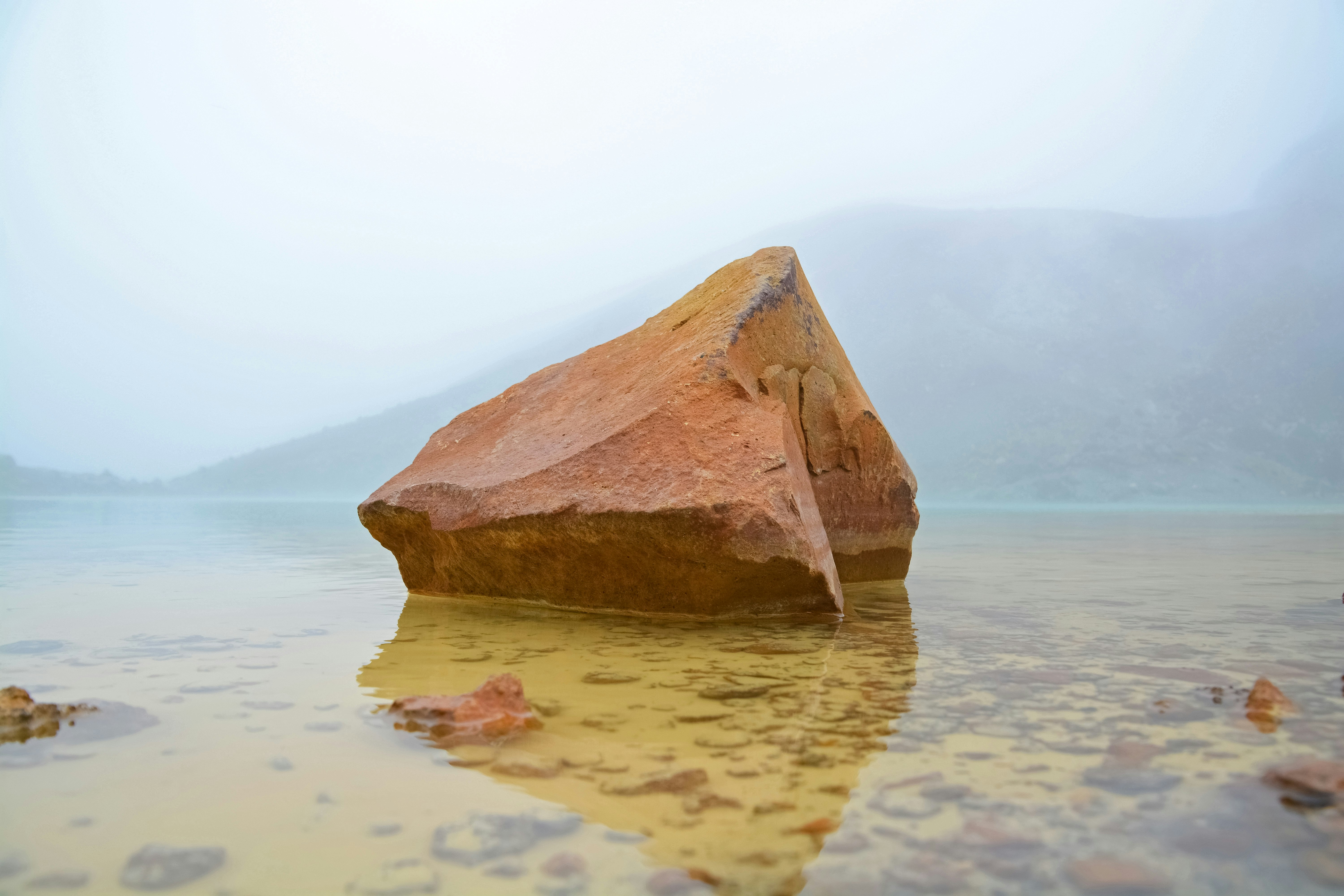 brown rock on body of water during daytime